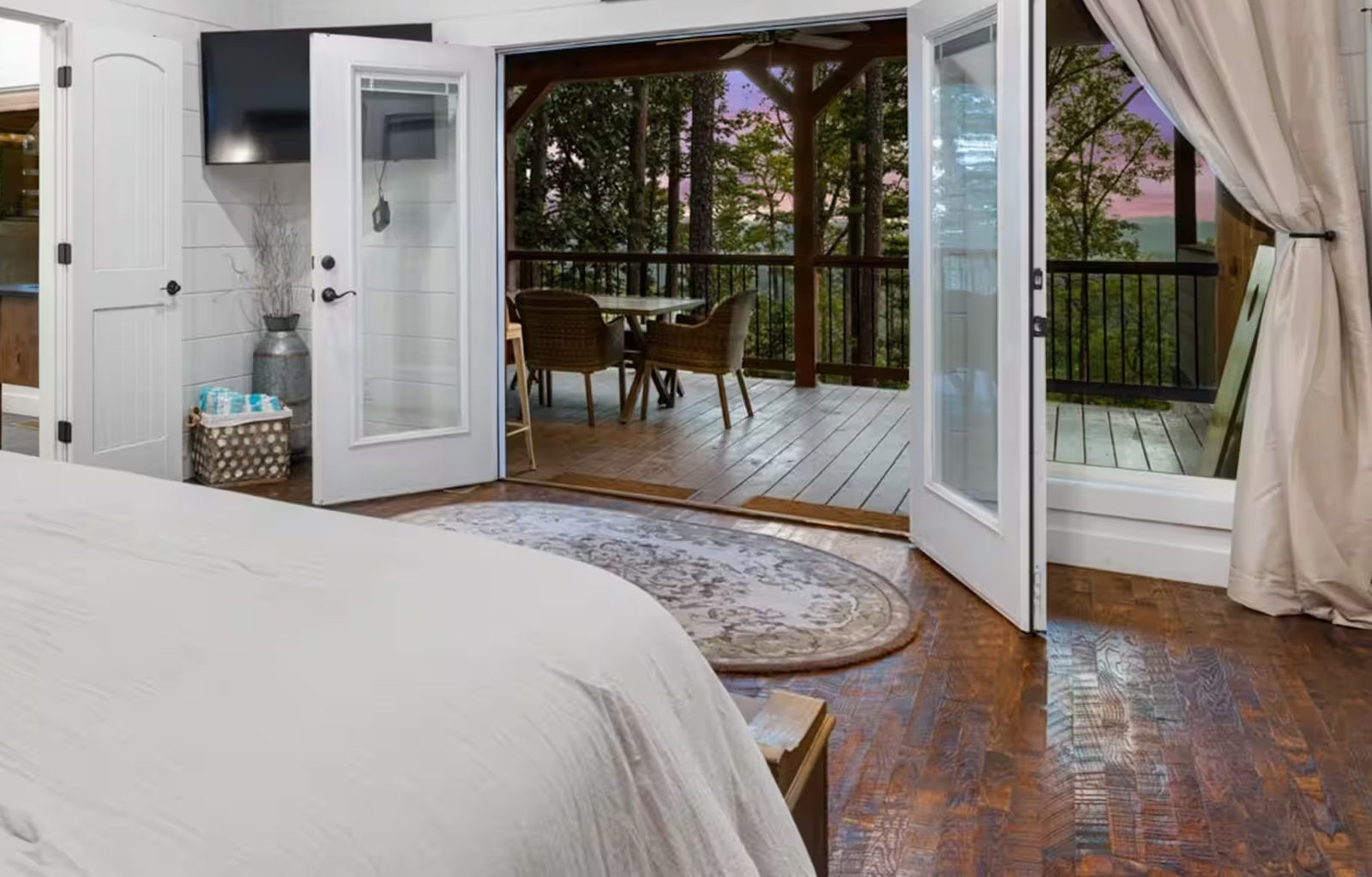 Primary suite opening through French doors toward the deck.